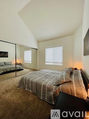 Huntington Beach condo for rent - A bedroom with a large bed and a mirror on the wall.