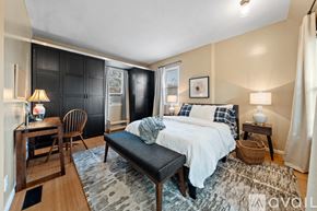 Tacoma apartment for rent - A bedroom with a bed, chair, and a table with a lamp on it.