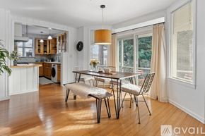 Tacoma apartment for rent - A dining area with a table and chairs in the foreground and a kitchen area in the background.