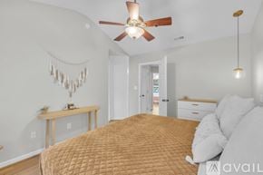 Apex townhouse for rent - A bedroom with a bed, a ceiling fan, and a window.