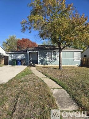 San Antonio apartment for rent - A tree with yellow leaves stands in front of a grey building.