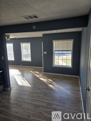 San Antonio apartment for rent - A room with wooden floors and a window overlooking a balcony.