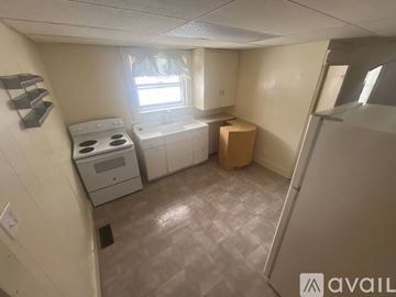 Cambridge house for rent - A small kitchen with a white stove and a window.