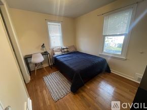 Syracuse apartment for rent - A bedroom with a bed, chair, and window.