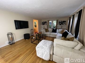 Syracuse apartment for rent - A living room with a white couch and a black coffee table.