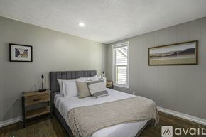 Grand Rapids apartment for rent - A bedroom with a bed, nightstand, and two pictures on the wall.