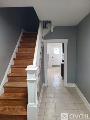 Baltimore house for rent - A staircase with wooden steps and white railings leads to a doorway.
