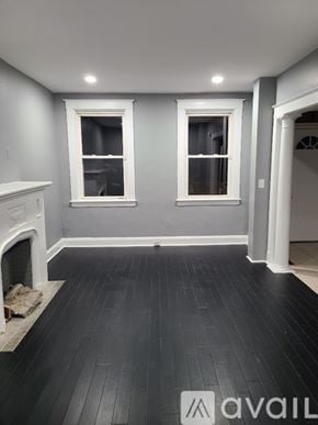 Baltimore house for rent - A room with a fireplace and two windows.