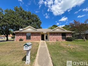 Overton apartment for rent - A house with a brick facade and a green lawn in front.