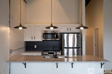 Toledo apartment for rent - A kitchen with a stainless steel refrigerator and a black and white backsplash.