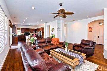Palm Desert house for rent - A living room with a brown leather couch and a wooden coffee table.