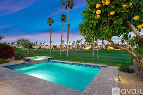 La Quinta house for rent - A pool surrounded by palm trees and a lemon tree.