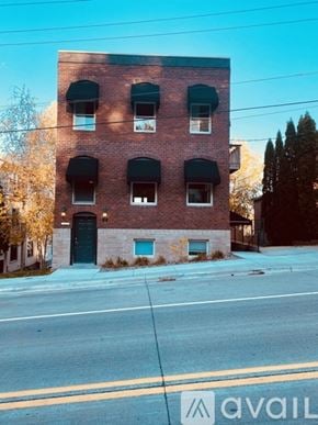 Stillwater apartment for rent - A red brick building with a black door and windows.