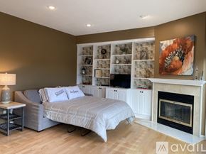 Stillwater apartment for rent - A bedroom with a grey bed and a fireplace.