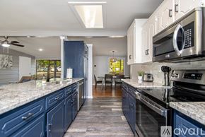 Jacksonville house for rent - A kitchen with blue cabinets and a black stove top oven.