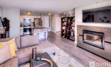 Chicago condo for rent - A living room with a grey couch and a fireplace.
