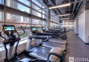 Chicago condo for rent - A gym with treadmills and a view of the city outside the windows.