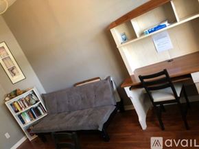Apopka apartment for rent - A living room with a grey couch, a wooden chair, and a white chair.