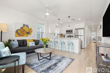 Boston apartment for rent - A living room with a grey couch, a coffee table, and a painting of a butterfly on the wall.