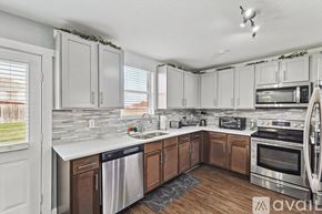 Grand Prairie house for rent - A kitchen with white cabinets and a stainless steel dishwasher.