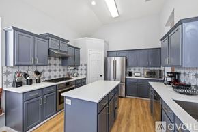 Haltom City house for rent - A kitchen with dark blue cabinets and a white countertop.