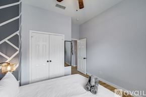 Haltom City house for rent - A bedroom with a large bed and a mirror on the wall.