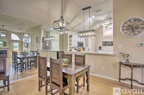 Rowlett house for rent - A dining room with wooden furniture and a large clock on the wall.