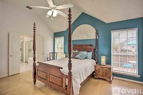 Rowlett house for rent - A bedroom with a large bed and a ceiling fan.