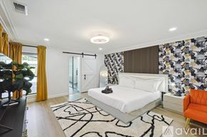 Plano house for rent - A bedroom with a white bed and orange chair.