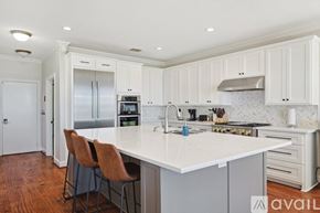 Rockwall house for rent - A kitchen with white cabinets and a marble backsplash.