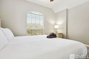 Rockwall house for rent - A bedroom with a large bed and a window with blinds.