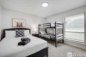 Lewisville house for rent - A bedroom with a large bed and a bunk bed.