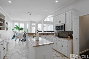 Rowlett house for rent - A kitchen with white cabinets and a marble countertop.