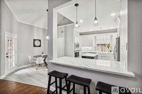 Rowlett house for rent - A kitchen with a bar and stools in front of a large mirror.
