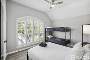 Rowlett house for rent - A bedroom with a bunk bed and a window with shutters.