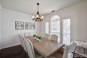 Plano house for rent - A dining room with a wooden table and white chairs.