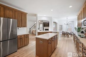 Highland Village house for rent - A modern kitchen with wooden cabinets and a stainless steel refrigerator.