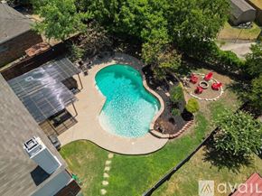 Saginaw house for rent - A backyard with a kidney-shaped pool and a hot tub.