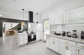Lancaster house for rent - A modern kitchen with white cabinets and a marble countertop.