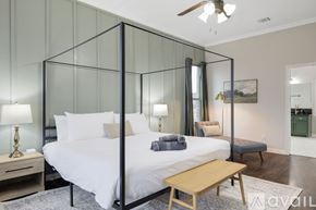Waxahachie house for rent - A bedroom with a four poster bed and a ceiling fan.