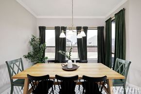 Waxahachie house for rent - A dining room with a wooden table and green chairs.