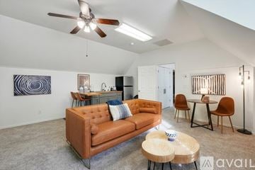 Keller house for rent - A living room with a brown couch, a ceiling fan, and a dining table with chairs.