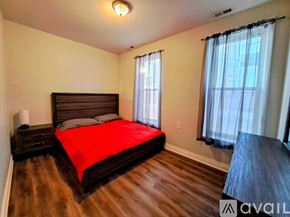 Chicago apartment for rent - A bedroom with a large bed and wooden floors.