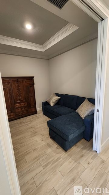Bradenton townhouse for rent - A living room with a dark blue couch and a wooden cabinet.