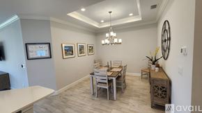 Bradenton townhouse for rent - A dining room with a table set for four and a chandelier hanging from the ceiling.