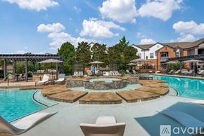 Lewisville apartment for rent - A large outdoor pool with a hot tub and lounge chairs.