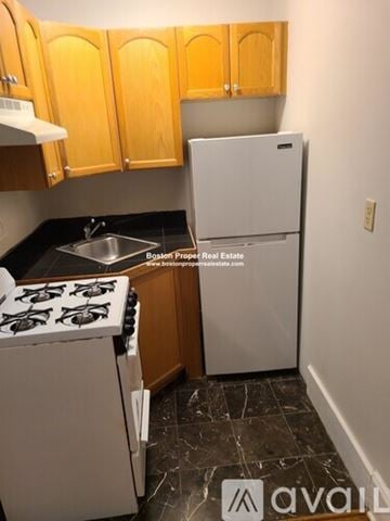 Boston apartment for rent - A kitchen with a white fridge and a white stove top.