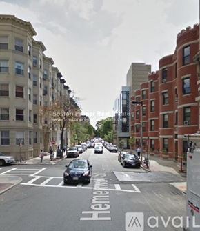 Boston apartment for rent - A street view of a city with cars and buildings.