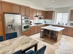 Huntington Beach townhouse for rent - A kitchen with wooden cabinets and a marble table.