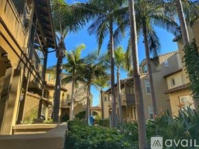 Huntington Beach townhouse for rent - A row of houses with palm trees in front.
